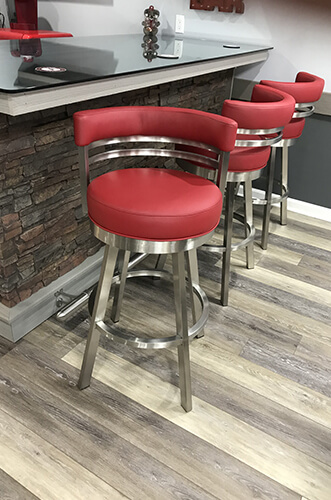 Wesley Allen's Miramar Modern Swivel Barstools in Stainless Steel and Red Vinyl - Shown in Modern Basement Bar