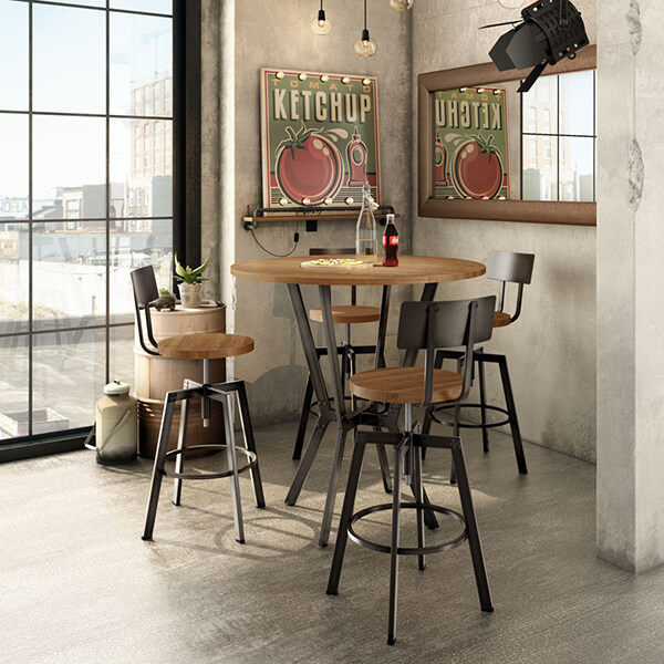 A metal and wood round pub table with four industrial style bar stools near a window